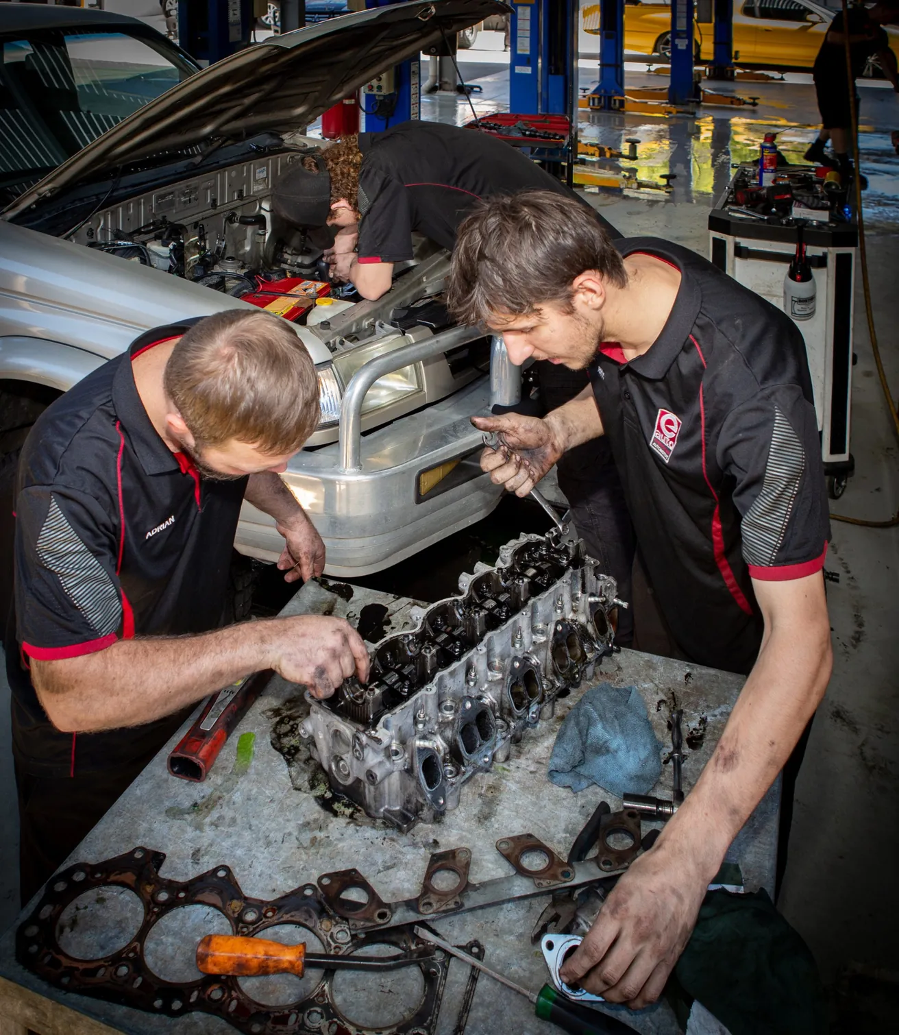 Two mechanics rebuilding an engine on the workshop bench